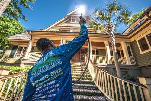 Pepper's Pressure Washing crew member cleaning a historic Charleston porch with professional equipment