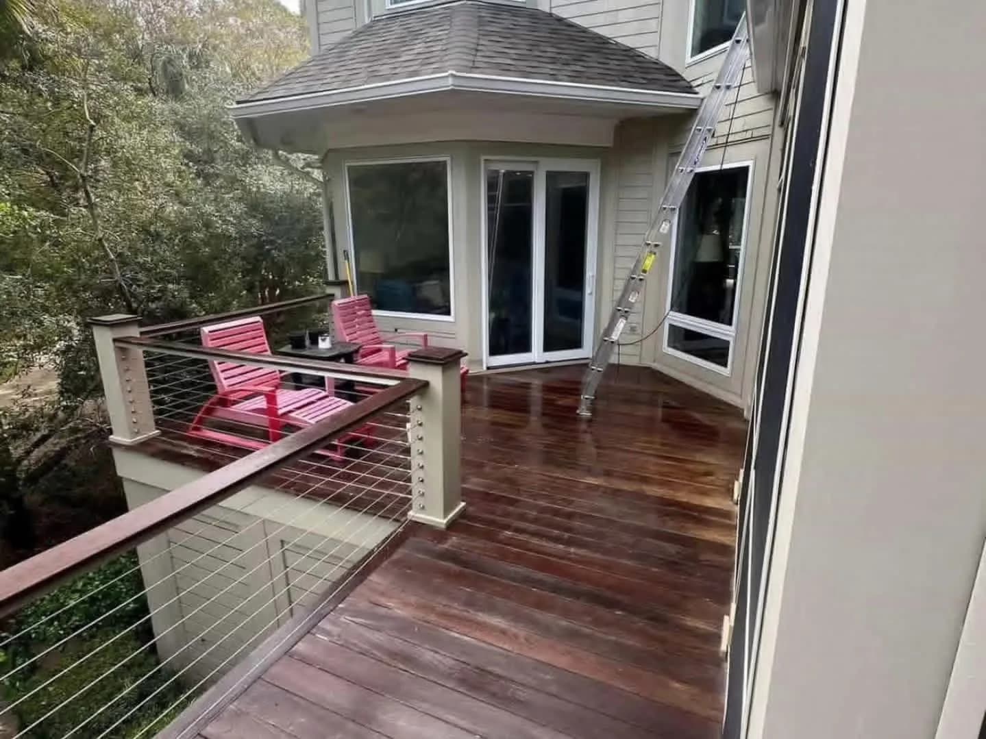 IPE deck boards restored to deep brown after cleaning, cable railing detail