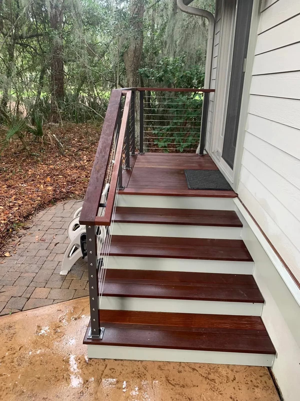 Wooden porch steps with restored treads and clean white risers after washing