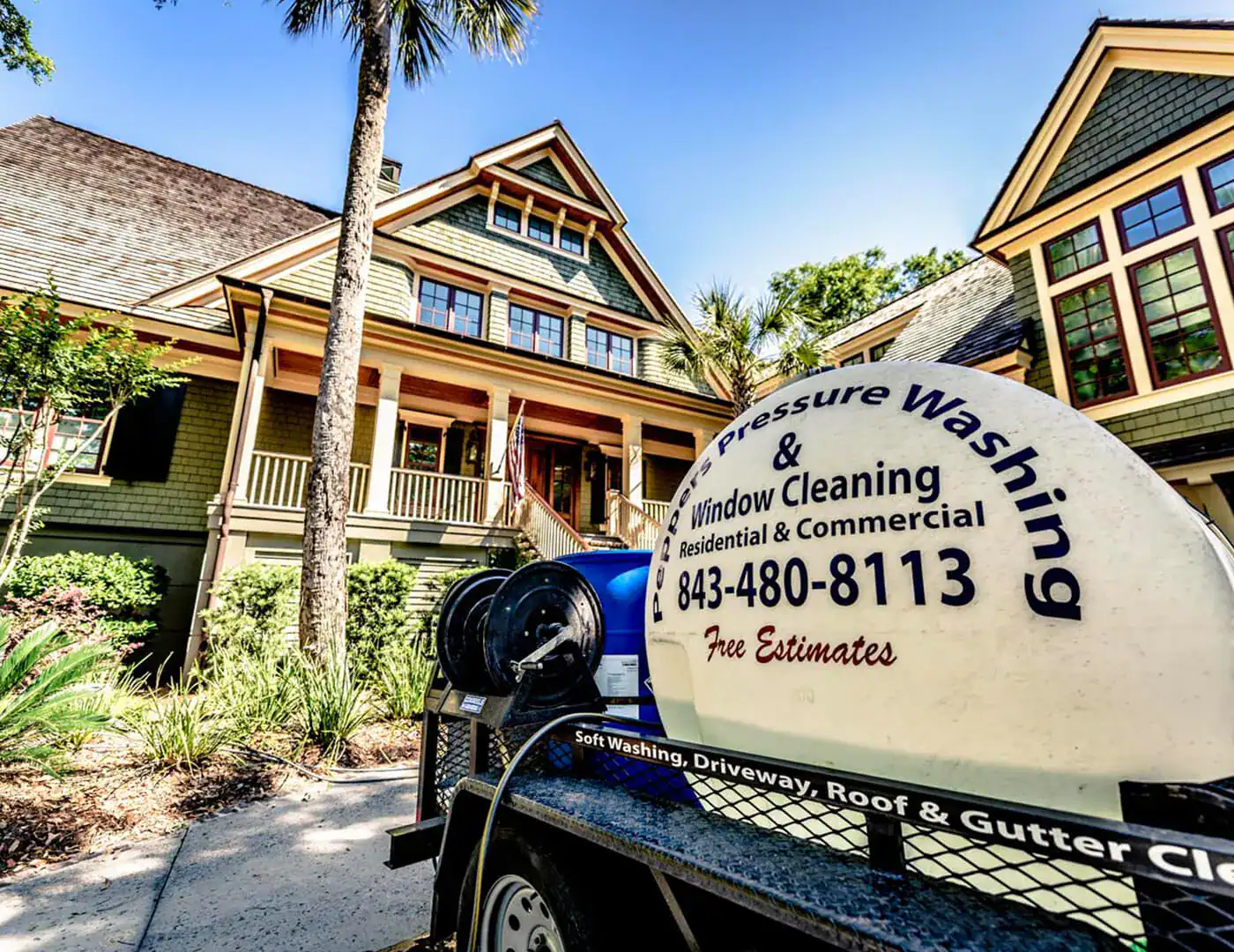 A clean Charleston Lowcountry home with white siding and a wraparound porch