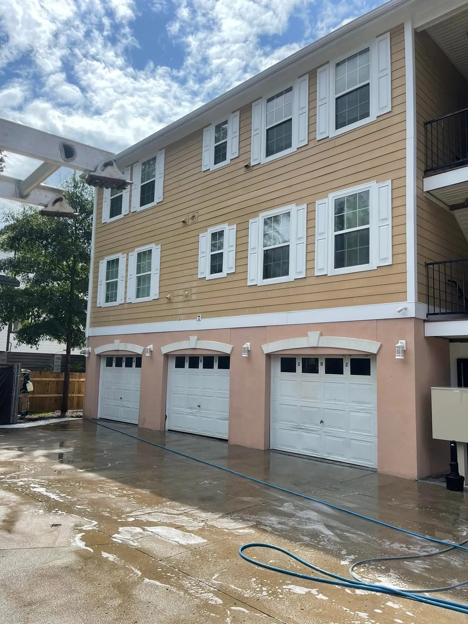Yellow vinyl siding on Charleston townhouse cleaned and restored after professional soft-wash by Pepper's Pressure Washing